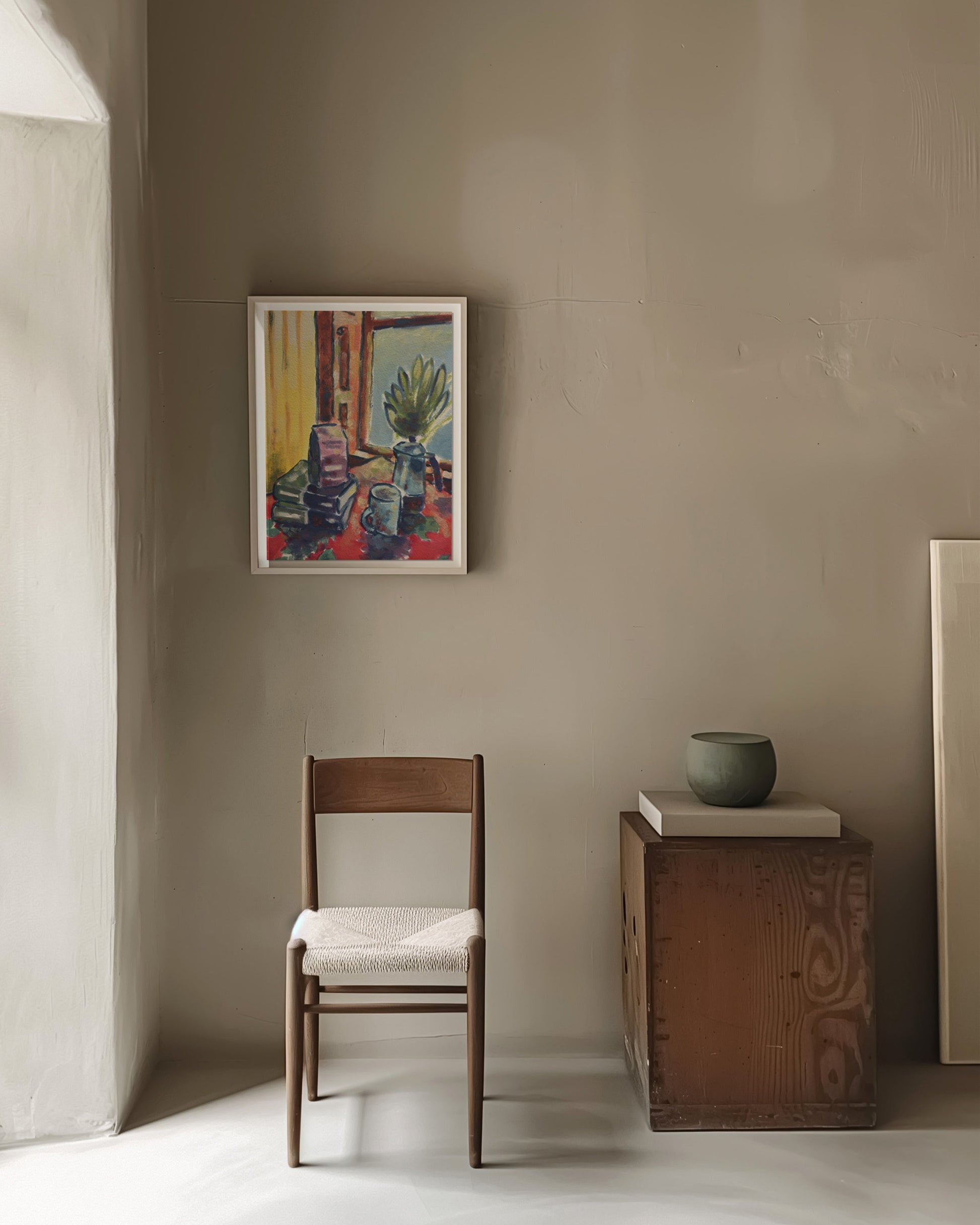 Room interior with a chair, small table, and framed artwork on a beige wall.