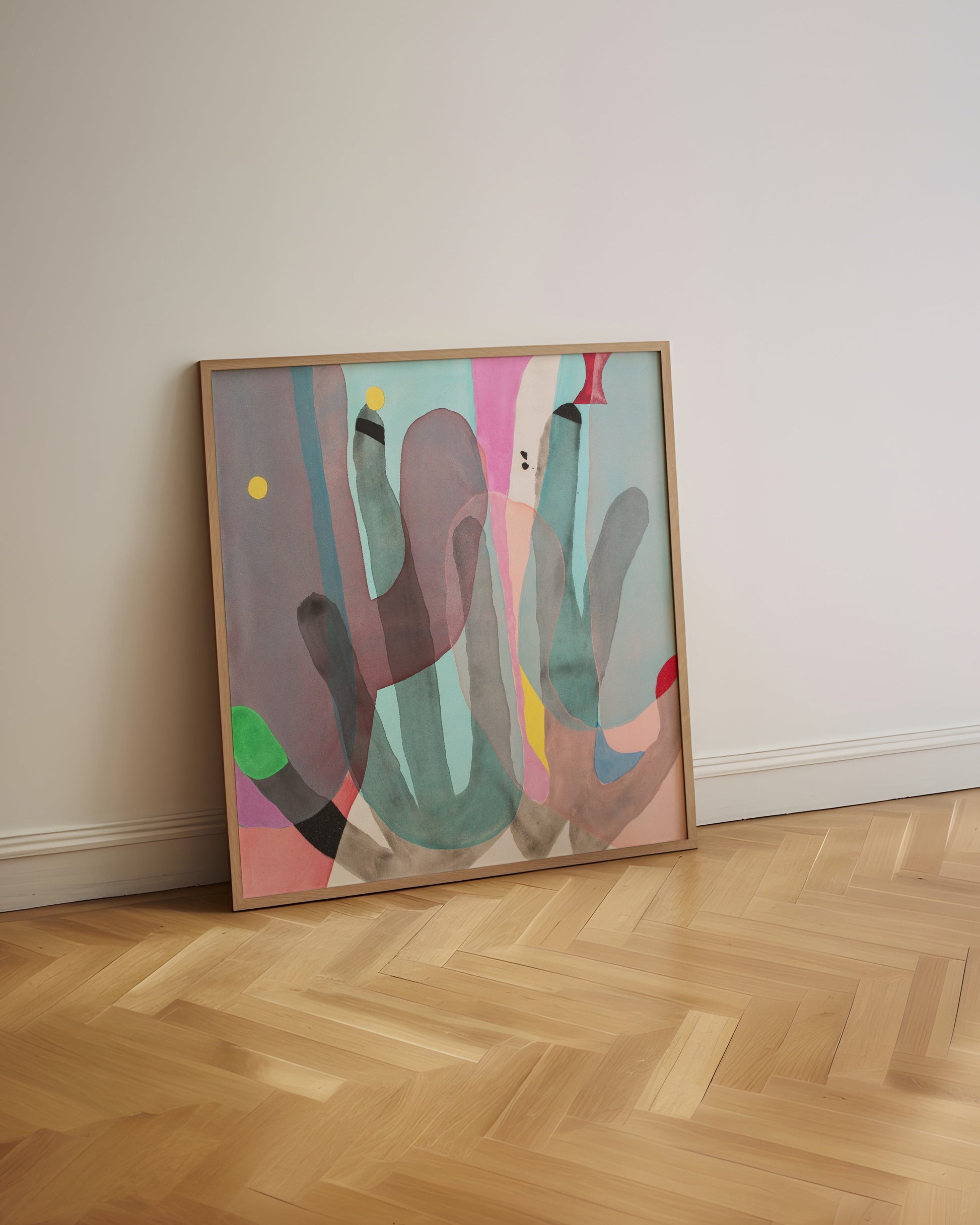 Colorful abstract artwork in a wooden frame leaning on a white wall with a herringbone wooden floor.