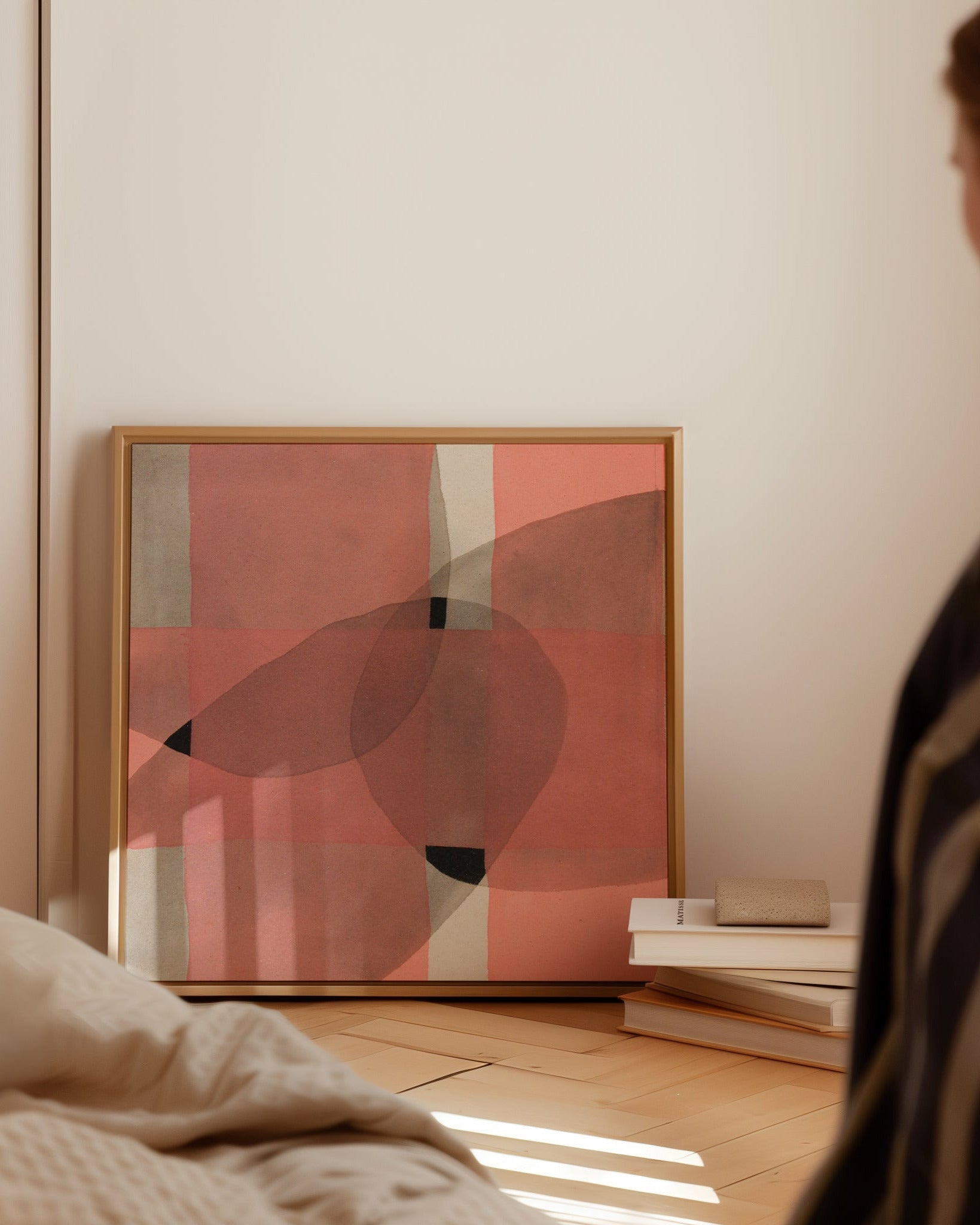 Abstract art painting leaning against a wall with a woman looking at it.