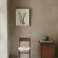 Minimalist interior with a chair, small table, and abstract painting.