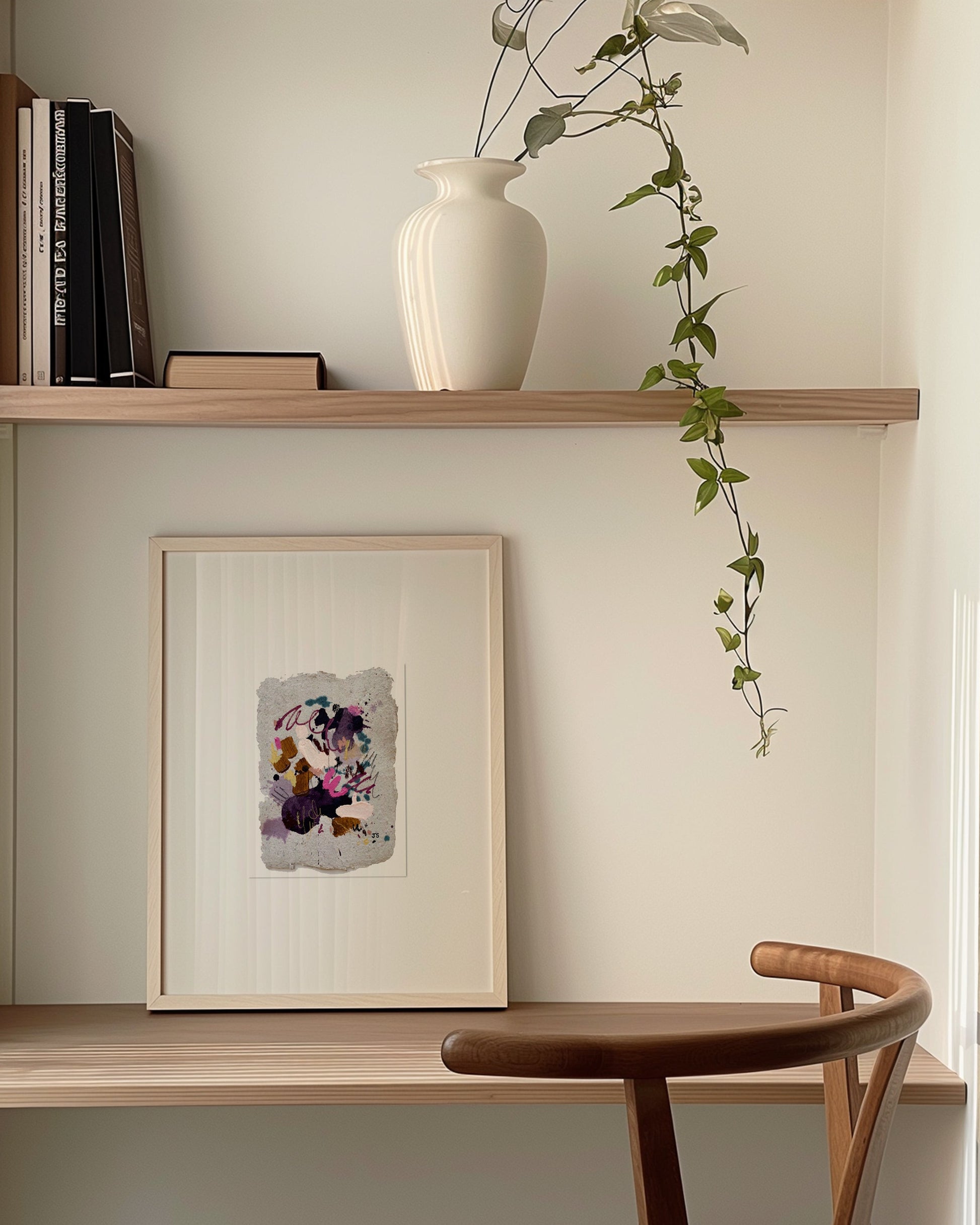 Small framed abstract painting on a desk.