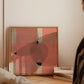 Abstract art painting leaning against a wall with a woman looking at it.