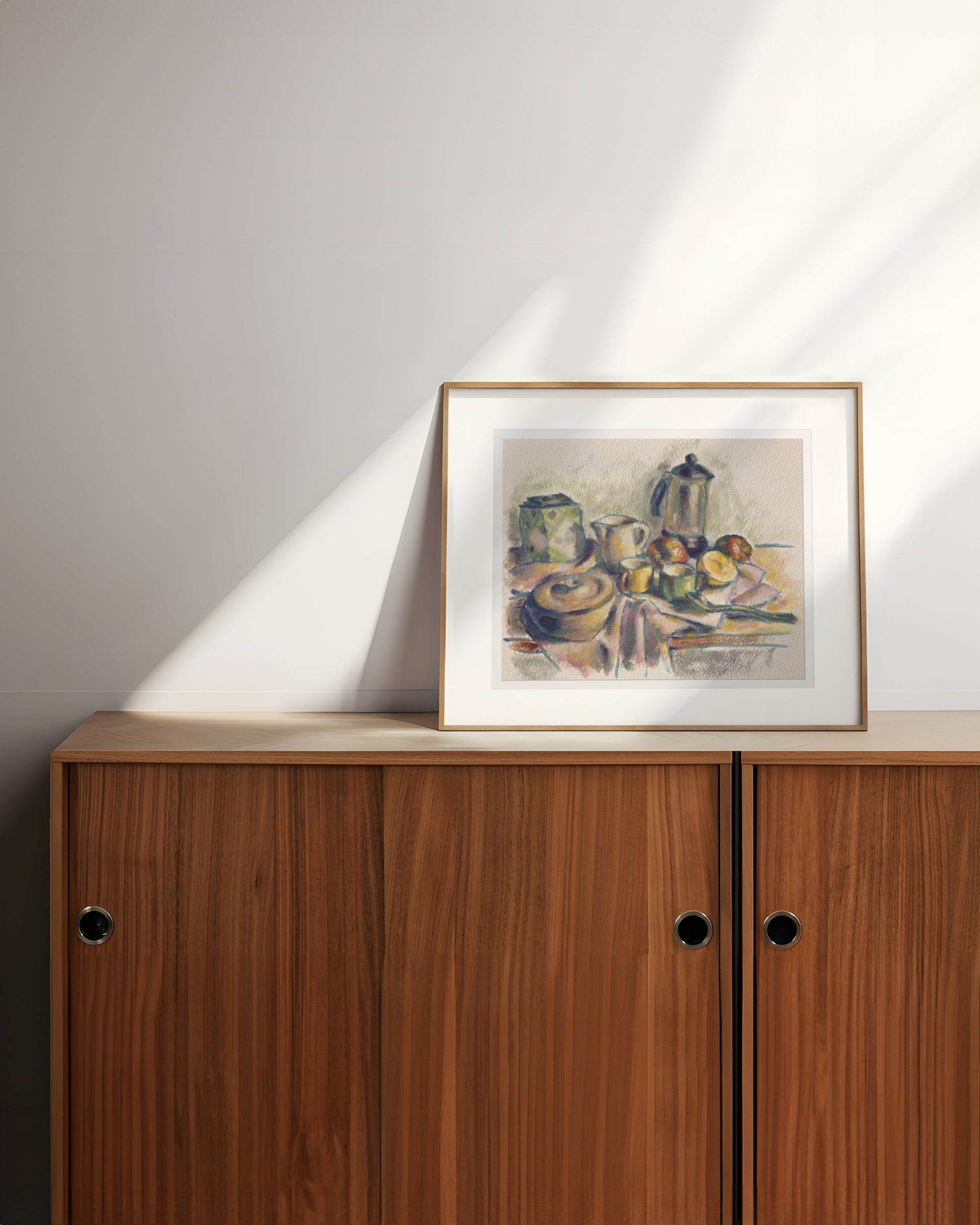 Framed still life artwork on a wooden cabinet 