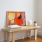 Colorful abstract painting on a wooden bench leaning against a white wall.