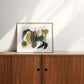 Framed abstract artwork on a wooden cabinet.