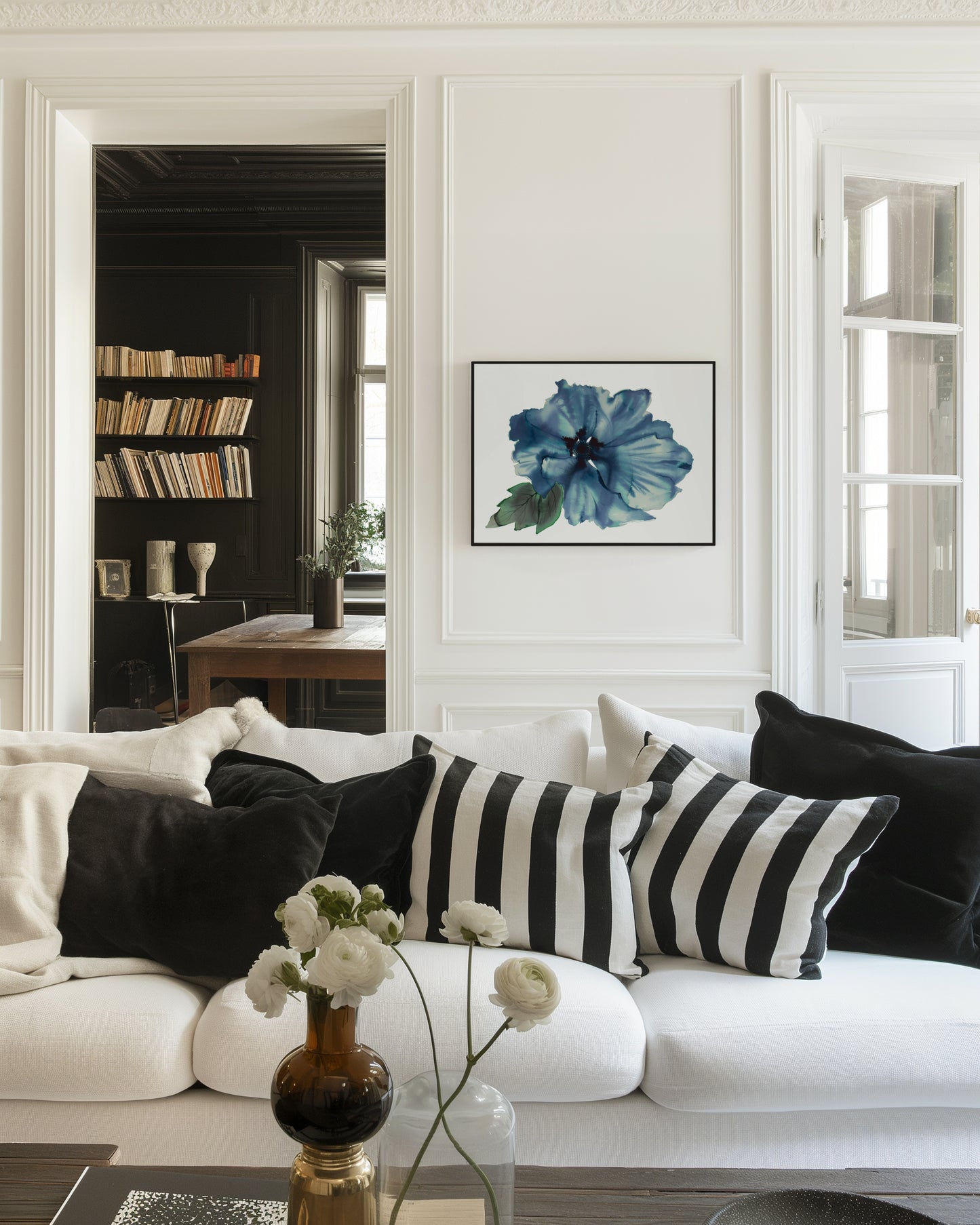 Living room with black and white decor and a blue floral painting on the wall.