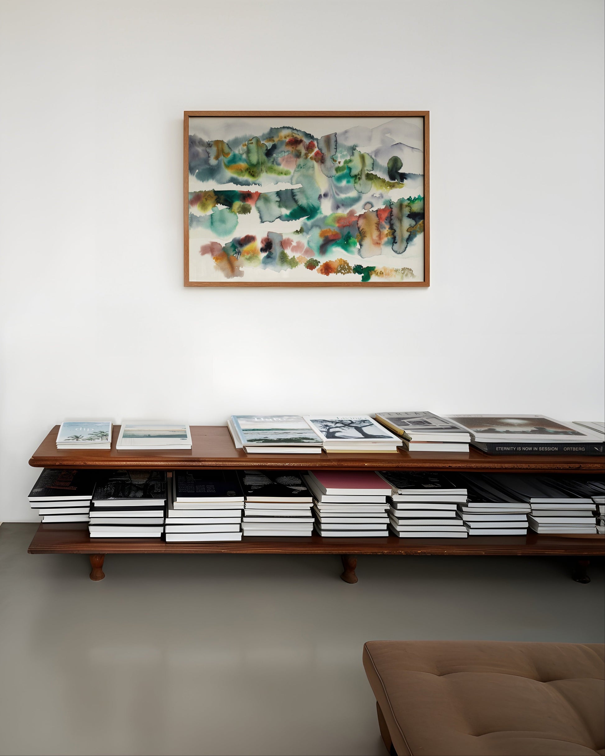 Living room with framed colorful abstract landscape painting on a white wall.