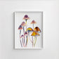 Framed artwork of watercolor mushrooms on a white wall