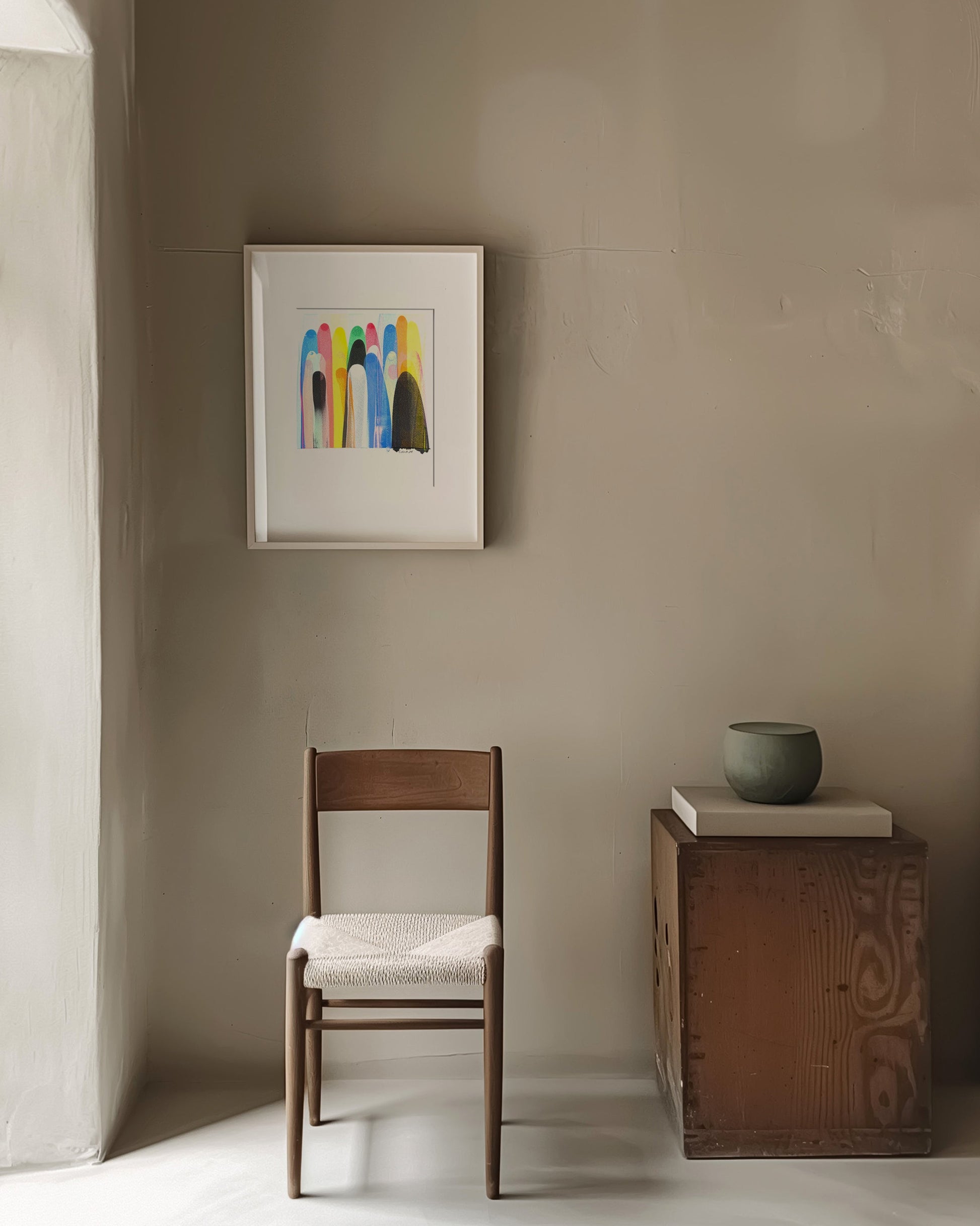 Minimalist room with a wooden chair, small table, and framed artwork.