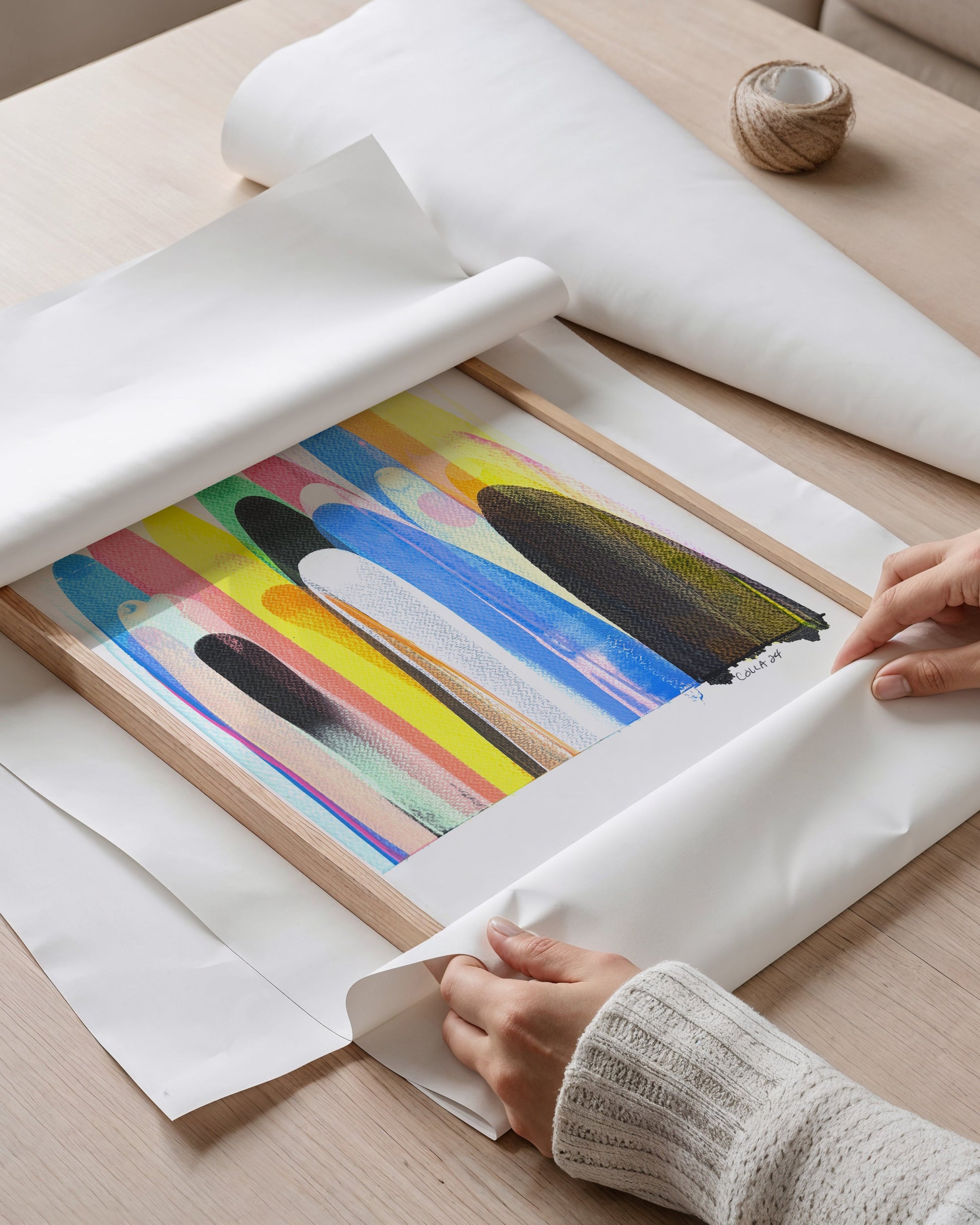 Person wrapping a colorful abstract painting.