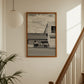 Framed black and white photo of a truck on a wall next to a staircase
