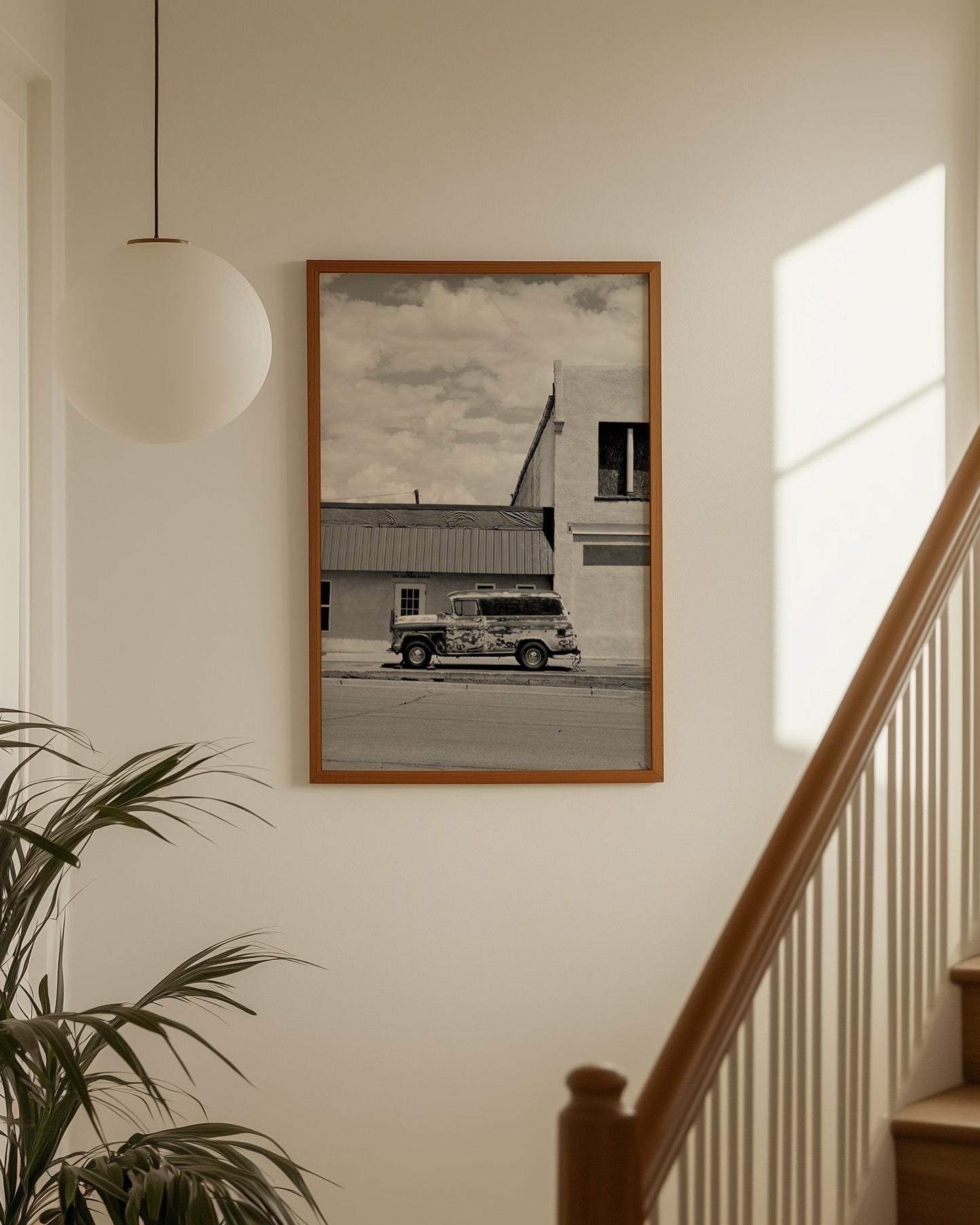 Framed black and white photo of a truck on a wall next to a staircase